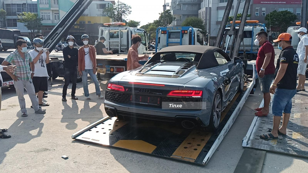 Người d&acirc;n đứng xem Audi R8 V10 Spyder 2021 đang được vận chuyển xuống đường để tập trung lại c&ugrave;ng c&aacute;c si&ecirc;u xe kh&aacute;c.