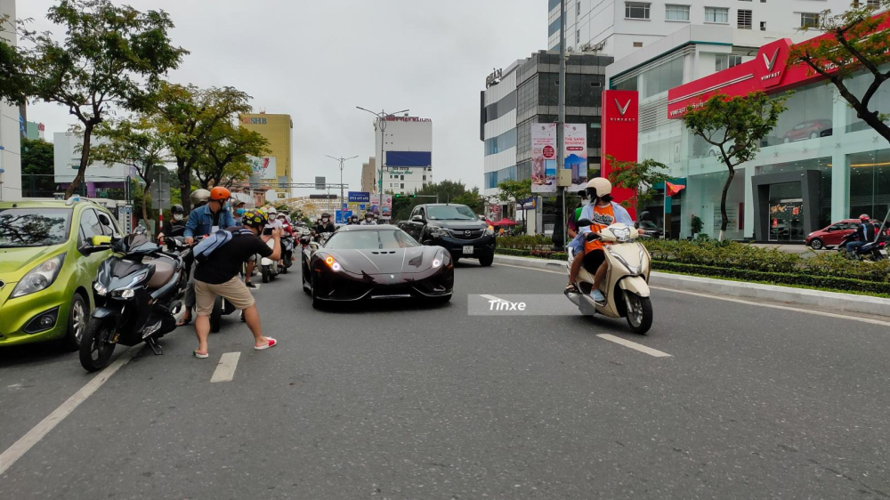 Sự xuất hiện của Koenigsegg Regera đ&atilde; thu h&uacute;t h&agrave;ng trăm bạn trẻ m&ecirc; xe theo d&otilde;i, trong ảnh d&ugrave; đang điều khiển xe m&aacute;y đi đường nhưng người phụ nữ v&agrave; con trai vẫn quay đầu để ngắm si&ecirc;u phẩm Koenigsegg Regera do Ho&agrave;ng Kim Kh&aacute;nh điều khiển.
