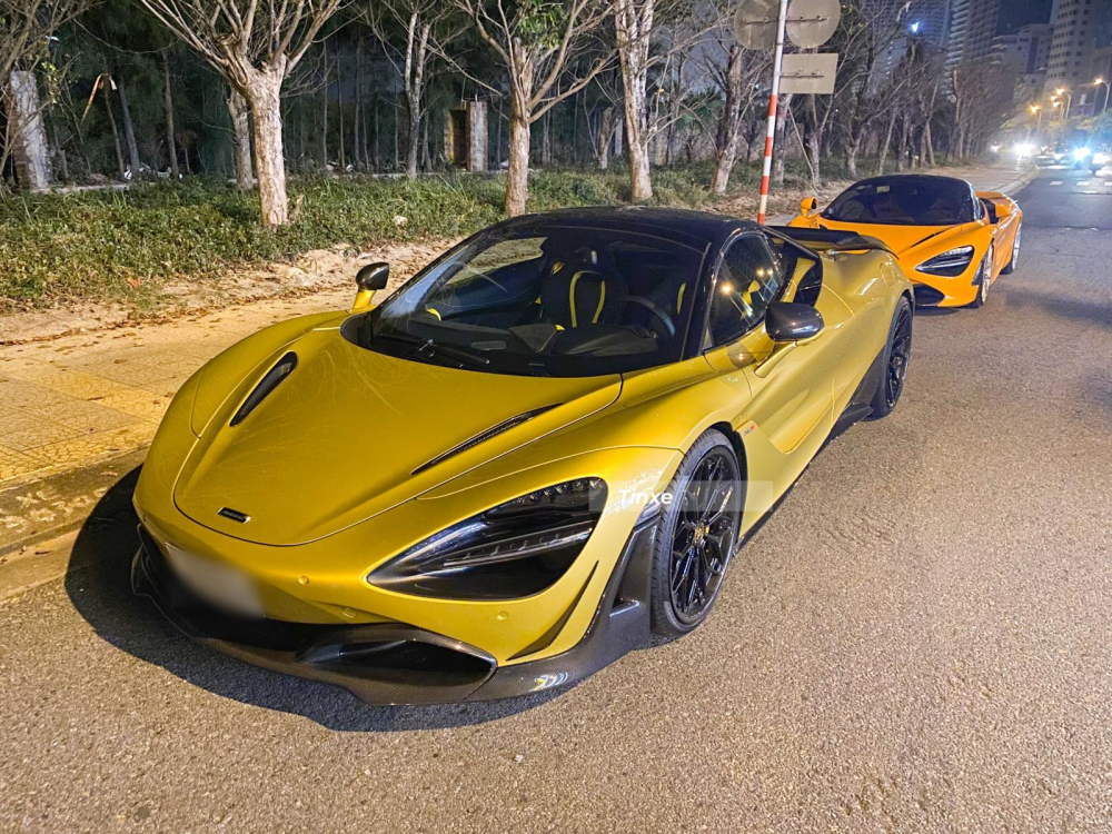 Đỗ trước si&ecirc;u xe McLaren 720S m&agrave;u cam l&agrave; bản mui trần McLaren 720S Spider c&oacute; g&oacute;i độ body kit carbon của Novitec