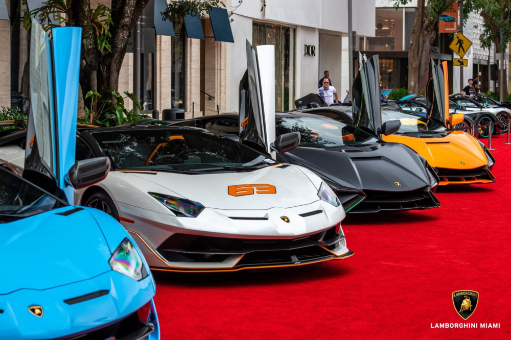 Siêu xe Lamborghini Aventador SVJ63 Roadster được trưng bày trong sự kiện mà anh Tuấn đã đến tham quan và bị thôi miên phải sở hữu bằng được, đỗ cạnh siêu xe mui trần là 2 chiếc Lamborghini Sian màu đen nhám và cam, ngoài ra còn có siêu xe Lamborghini Aventador SVJ Roadster màu xanh