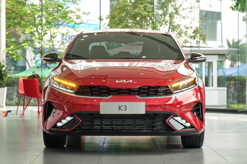Tổng thể ngoại thất của Kia K3 GT 2022 kh&ocirc;ng kh&aacute;c so với phi&ecirc;n bản thường nhưng vẫn rất dễ ph&acirc;n biệt nhờ những đường viền đỏ được bổ sung ở c&aacute;c thanh nan trong lưới tản nhiệt &ldquo;mũi hổ&rdquo; hay hốc đ&egrave;n sương m&ugrave;.