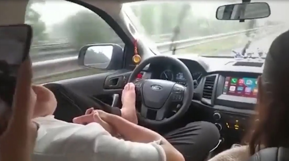 Video quay cảnh nam t&agrave;i xế l&aacute;i xe &ocirc; t&ocirc; bằng ch&acirc;n để nắm tay bạn g&aacute;i&nbsp;khiến người xem phẫn nộ