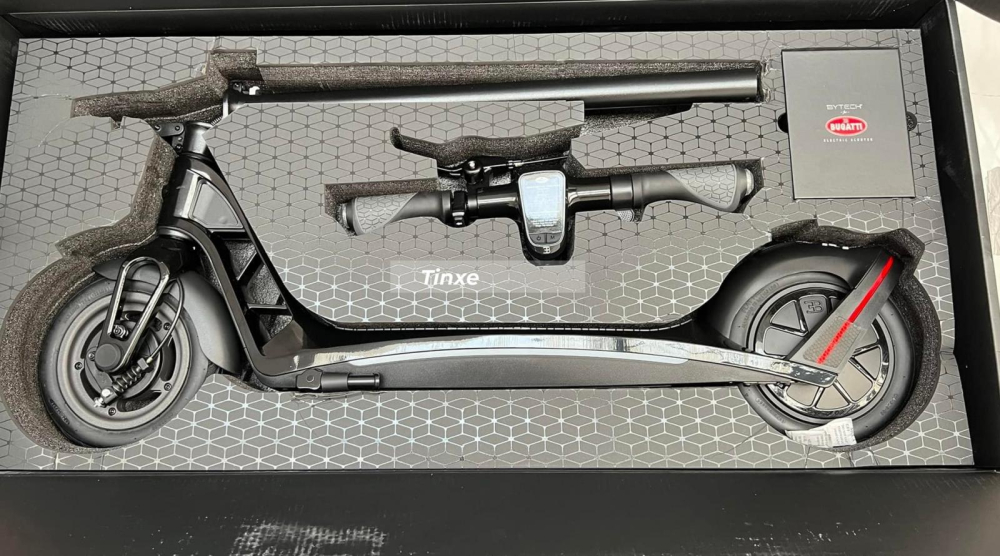 Tiếp đến l&agrave; chiếc xe Bugatti Scooter đ&atilde; được gấp gọn, ghi đ&ocirc;ng đ&atilde; th&aacute;o d&acirc;y điện ngo&agrave;i ra l&agrave; 1 hộp đựng bao gồm c&aacute;p sạc, mục lục
