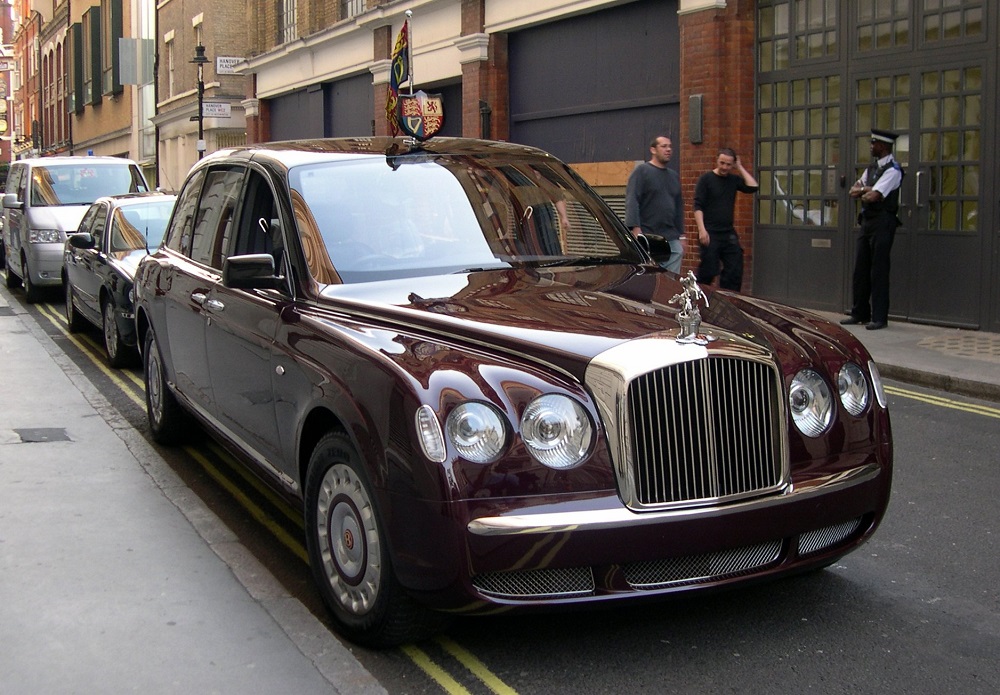 Trên nóc của chiếc Bentley State Limousine có phù hiệu áo giáp và cờ Trên nóc của chiếc Bentley State Limousine có phù hiệu áo giáp và cờ