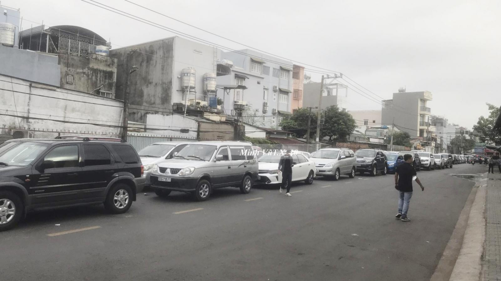 Hàng xe chuẩn bị làm đăng kiểm nối dài từ con đường trong hẻm ra đến quốc lộ 13, thường ngày, con đường này cũng đông xe đậu nhưng là xe của đại lý 1 hãng ô tô đầu đường đỗ nhờ Hàng xe chuẩn bị làm đăng kiểm nối dài từ con đường trong hẻm ra đến quốc lộ 13, thường ngày, con đường này cũng đông xe đậu nhưng là xe của đại lý 1 hãng ô tô đầu đường đỗ nhờ