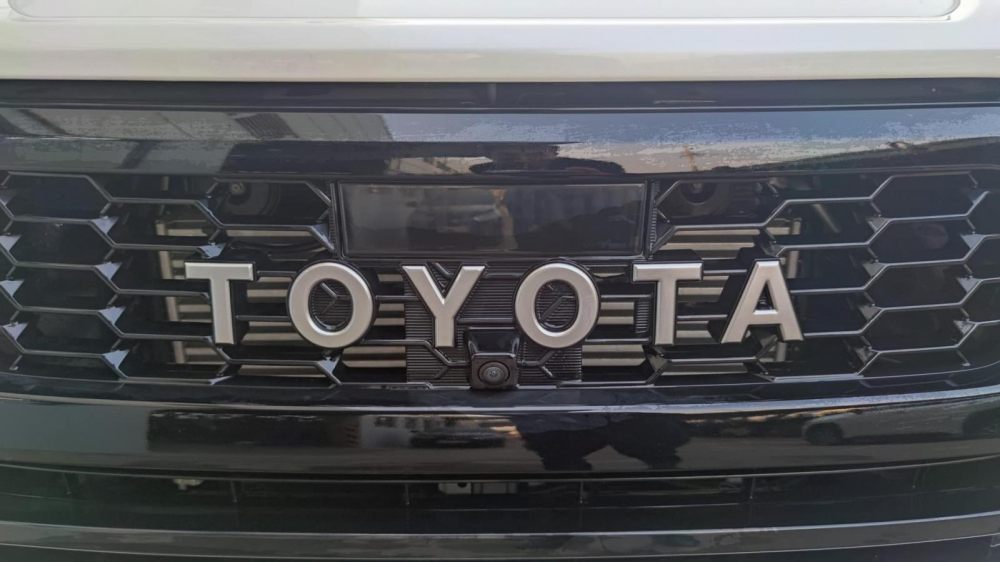 Dòng chữ Toyota màu trắng trên lưới tản nhiệt, thay cho logo của hãng Toyota Dòng chữ Toyota màu trắng trên lưới tản nhiệt, thay cho logo của hãng Toyota