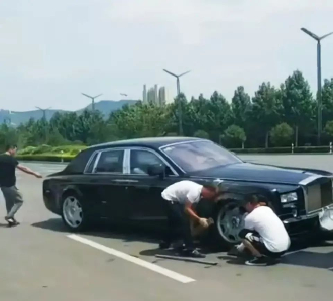 Hai người đ&agrave;n &ocirc;ng xem x&eacute;t thiệt hại của chiếc Rolls-Royce Phantom