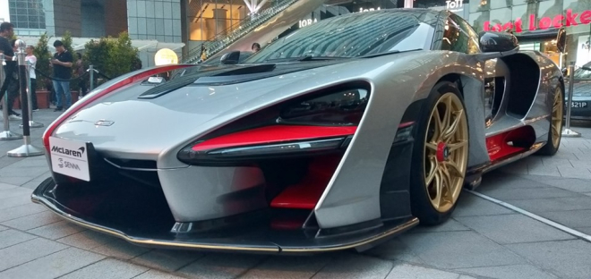 Chiếc McLaren Senna n&agrave;y c&oacute; m&agrave;u bạc đi k&egrave;m sợi carbon, c&aacute;c hoạ tiết đỏ cam v&agrave; bộ m&acirc;m v&agrave;ng đồng