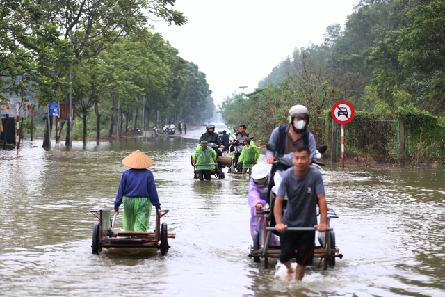 Hà Nội: Ngập sâu trên đại lộ Thăng Long, người dân phải bỏ 50.000 đồng thuê xe bò vượt qua- Ảnh 11.