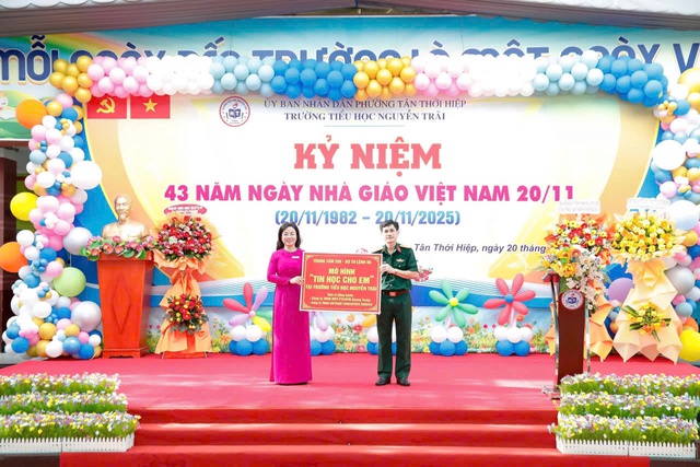 Đại tá Nguyễn Quốc Hoàn, BTĐU, Chính uỷ Trung tâm trao biểu trưng mô hình “Tin học cho em” cho cô Trần Thị Hồng Ân, Hiệu trưởng Trường Tiểu học Nguyễn Trãi.