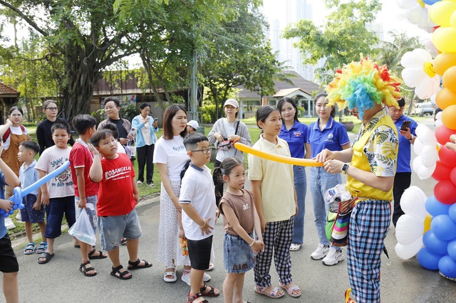 Các em thiếu nhi xếp hàng nhận những đồ chơi bóng bay. Các em thiếu nhi xếp hàng nhận những đồ chơi bóng bay.