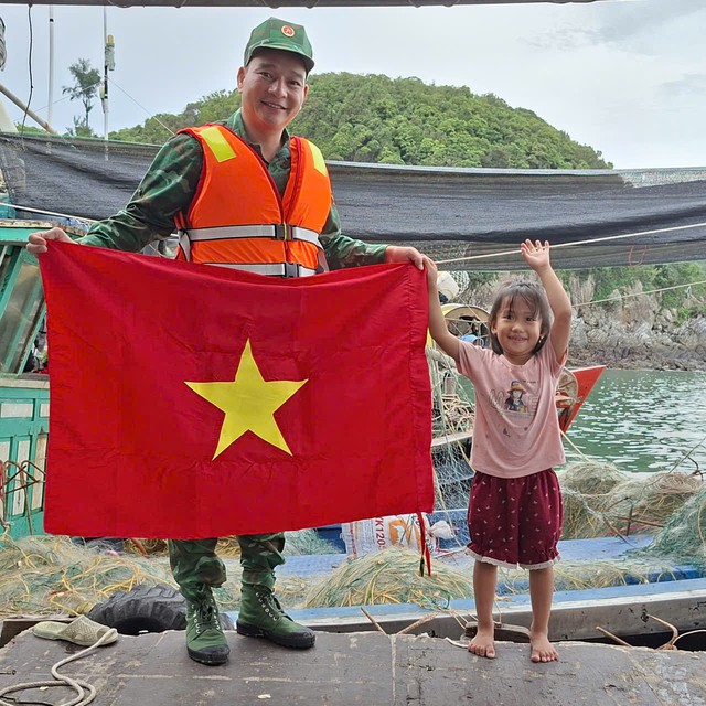 Bé gái nhỏ tuổi cũng phấn khởi khi được các chú Biên phòng tặng cờ cho gia đình. Bé gái nhỏ tuổi cũng phấn khởi khi được các chú Biên phòng tặng cờ cho gia đình.