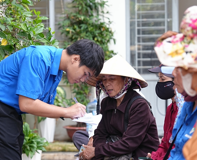 Bạn t&igrave;nh nguyện vi&ecirc;n đang lấy th&ocirc;ng tin của b&agrave; con.