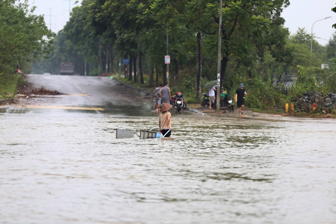 Hà Nội: Ngập sâu trên đại lộ Thăng Long, người dân phải bỏ 50.000 đồng thuê xe bò vượt qua- Ảnh 4.