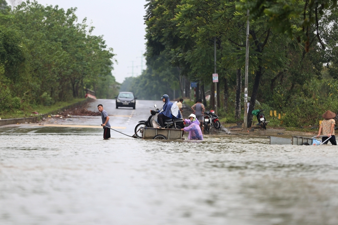 Hà Nội: Ngập sâu trên đại lộ Thăng Long, người dân phải bỏ 50.000 đồng thuê xe bò vượt qua- Ảnh 7.