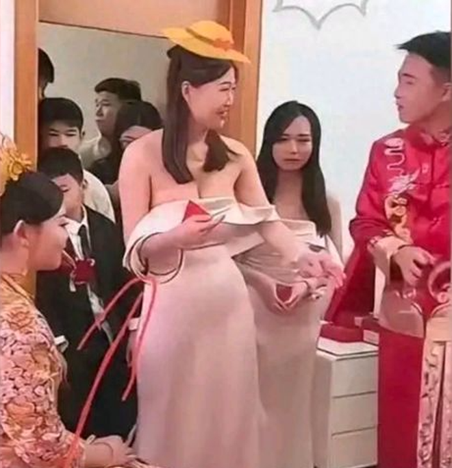 Ph&ugrave; d&acirc;u mặc v&aacute;y trễ vai "bấm c&ograve;i qua mặt c&ocirc; d&acirc;u" trong đ&aacute;m cưới, &aacute;nh mắt ch&uacute; rể mới lớn chuyện- Ảnh 1.