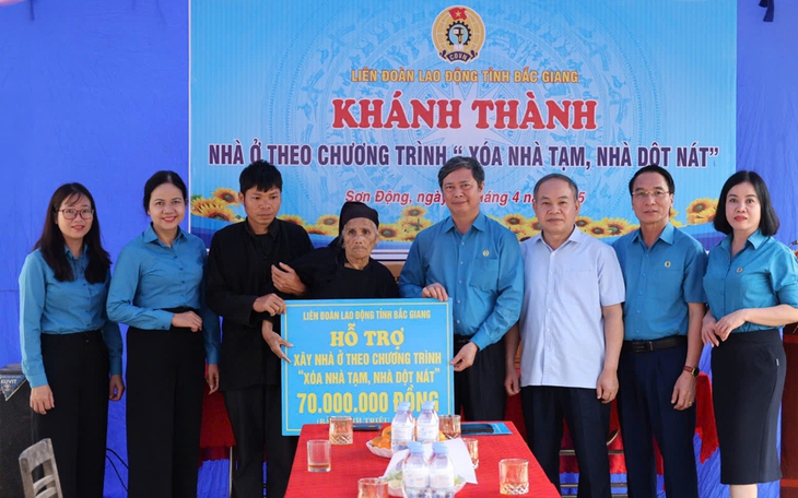 Lãnh đạo Liên đoàn Lao động tỉnh và Huyện ủy Sơn Động trao kinh phí hỗ trợ xây nhà cho gia đình bà Nhóp.