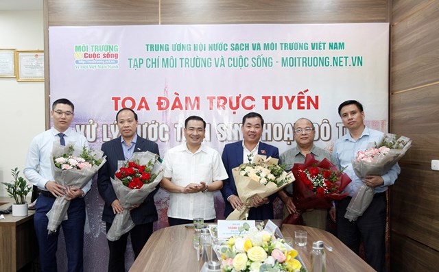 Nhà báo Nguyễn Văn Toàn – Tổng Biên tập Tạp chí Môi trường và Cuộc sống tặng hoa cho các khách mời tham dự tọa đàm.