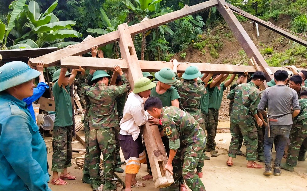 Cán bộ, chiến sĩ lực lượng vũ trang huyện Trạm Tấu giúp hộ nghèo tại xã Hát Lừu dựng nhà mới. (Ảnh cổng TTĐT tỉnh Yên Bái)