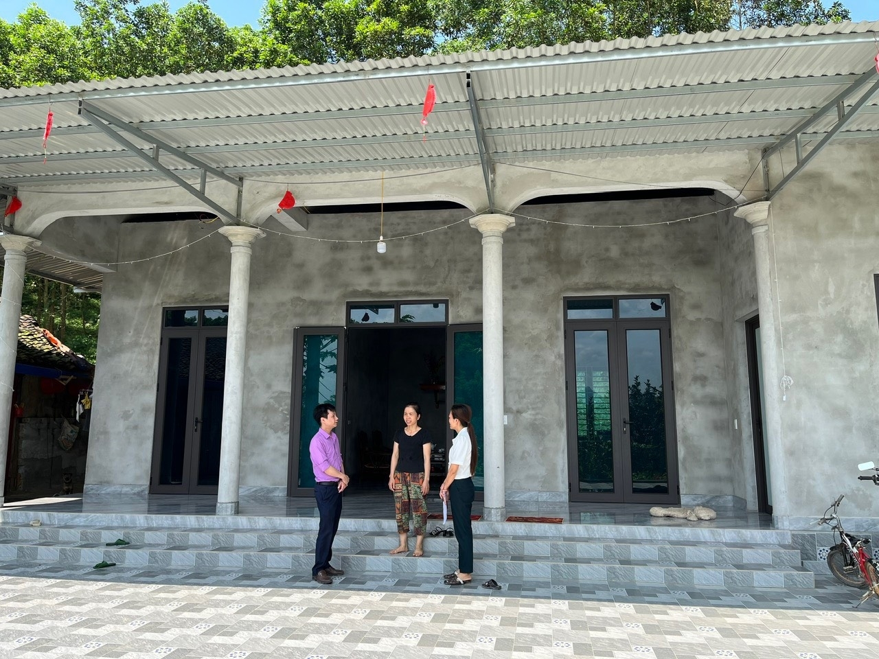 Chương trình MTQG 1719: Bệ đỡ vững chắc giúp đồng bào dân tộc thiểu số an cư, lập nghiệp- Ảnh 1. Chị Nguyễn Thị Uyên, xóm Vang, xã Liên Minh, huyện Võ Nhai, tỉnh Thái Nguyên phấn khởi chia sẻ với cán bộ huyện Võ Nhai khi được hỗ trợ xây dựng căn nhà mới khang trang, kiên cố. - Ảnh Báo Dân Tộc