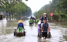 Hà Nội: Ngập sâu trên đại lộ Thăng Long, người dân phải bỏ 50.000 đồng thuê xe bò vượt qua