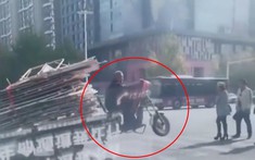 Ông lão điều khiển xe ba bánh qua ngã tư chỉ với hai bánh sau