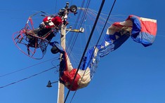 Đi phát quà bằng máy bay dù, "Ông già Noel" bị mắc vào dây điện và phải chờ giải cứu